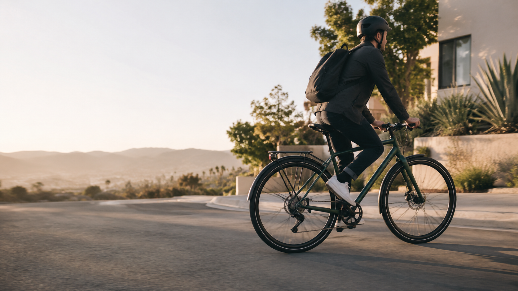 A commuter riding a bicycle through a Southern California neighborhood in morning light